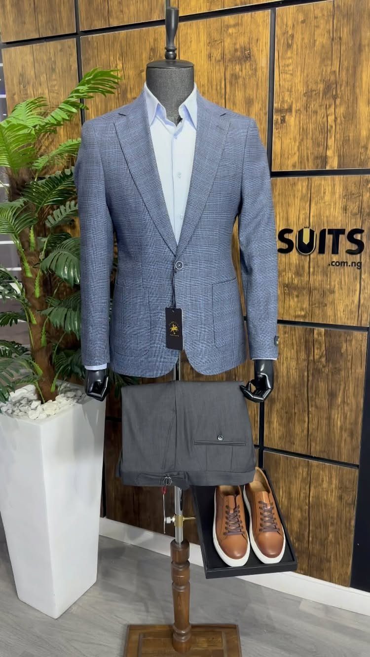 A blue patterned blazer on a mannequin paired with a light blue shirt and grey shorts.